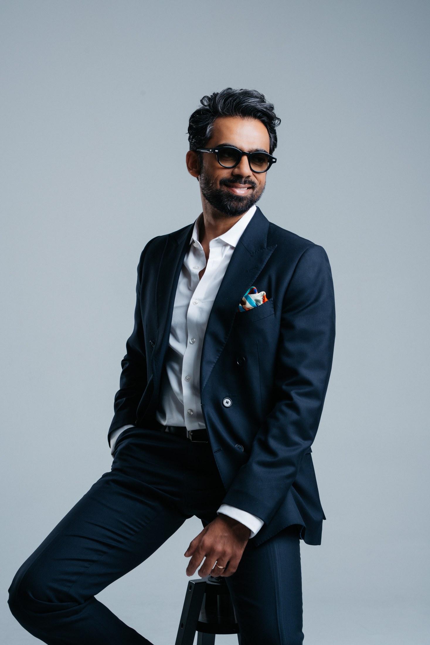 Kartik in a navy suit and sunglasses